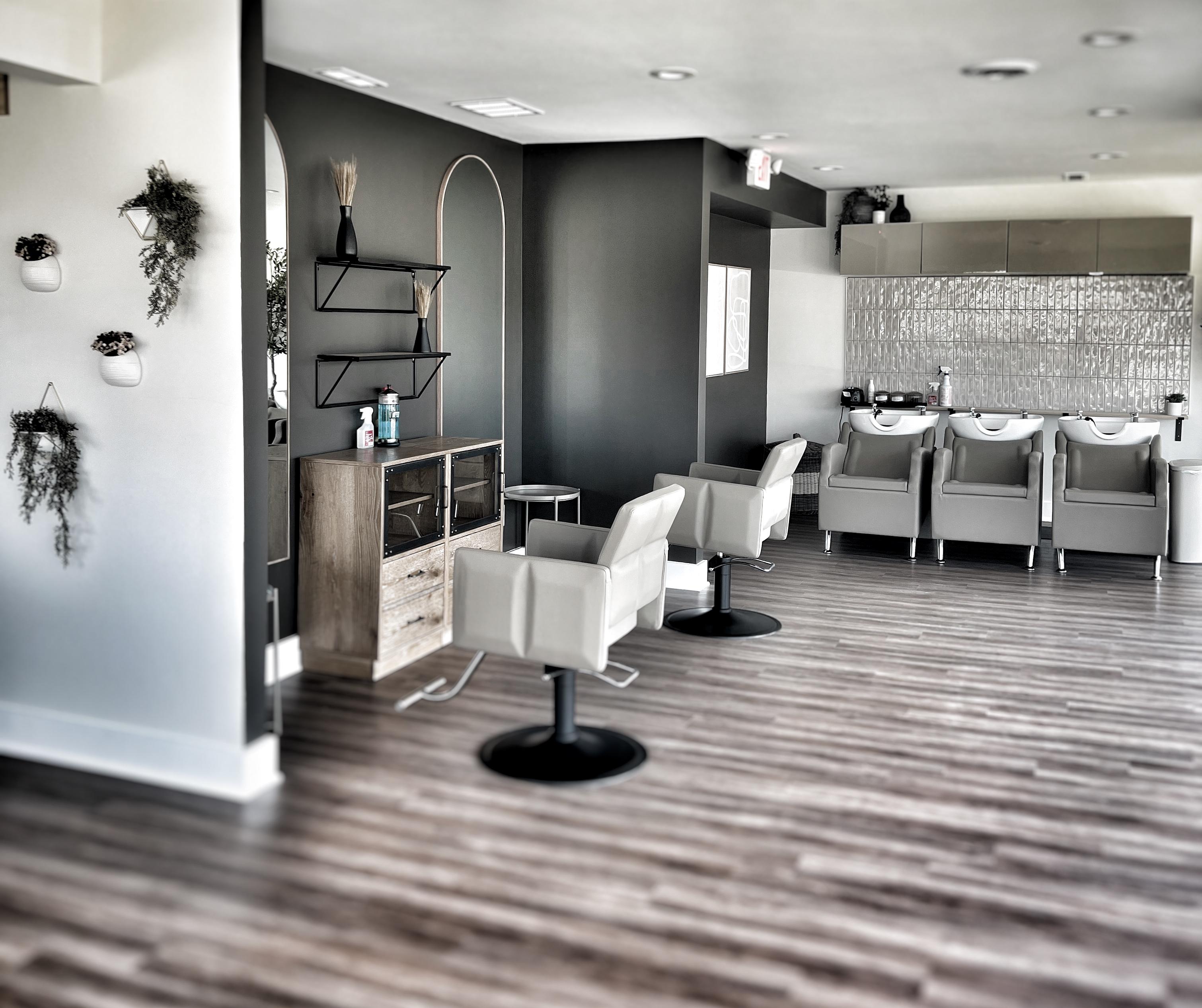 The rooted. salon — styling chairs, natural greenery, and warm wood floors